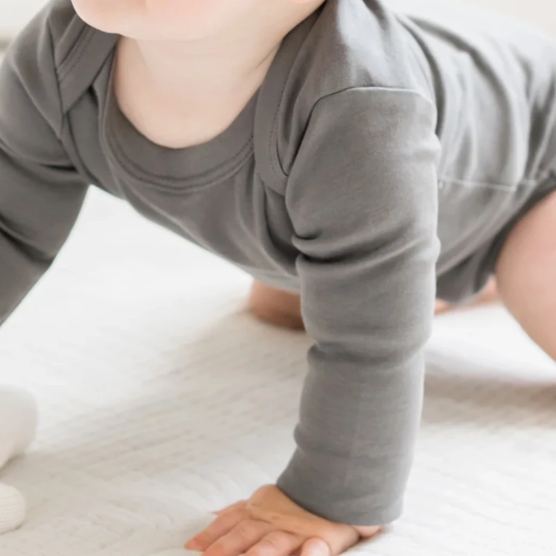 Premium organic bamboo baby rompers and spandex pajamas in bulk. Custom solid colors for B2B wholesale mystery box orders.